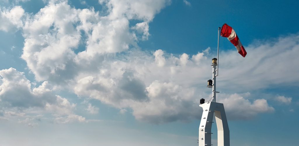 Windsock indicator of wind on sky background
